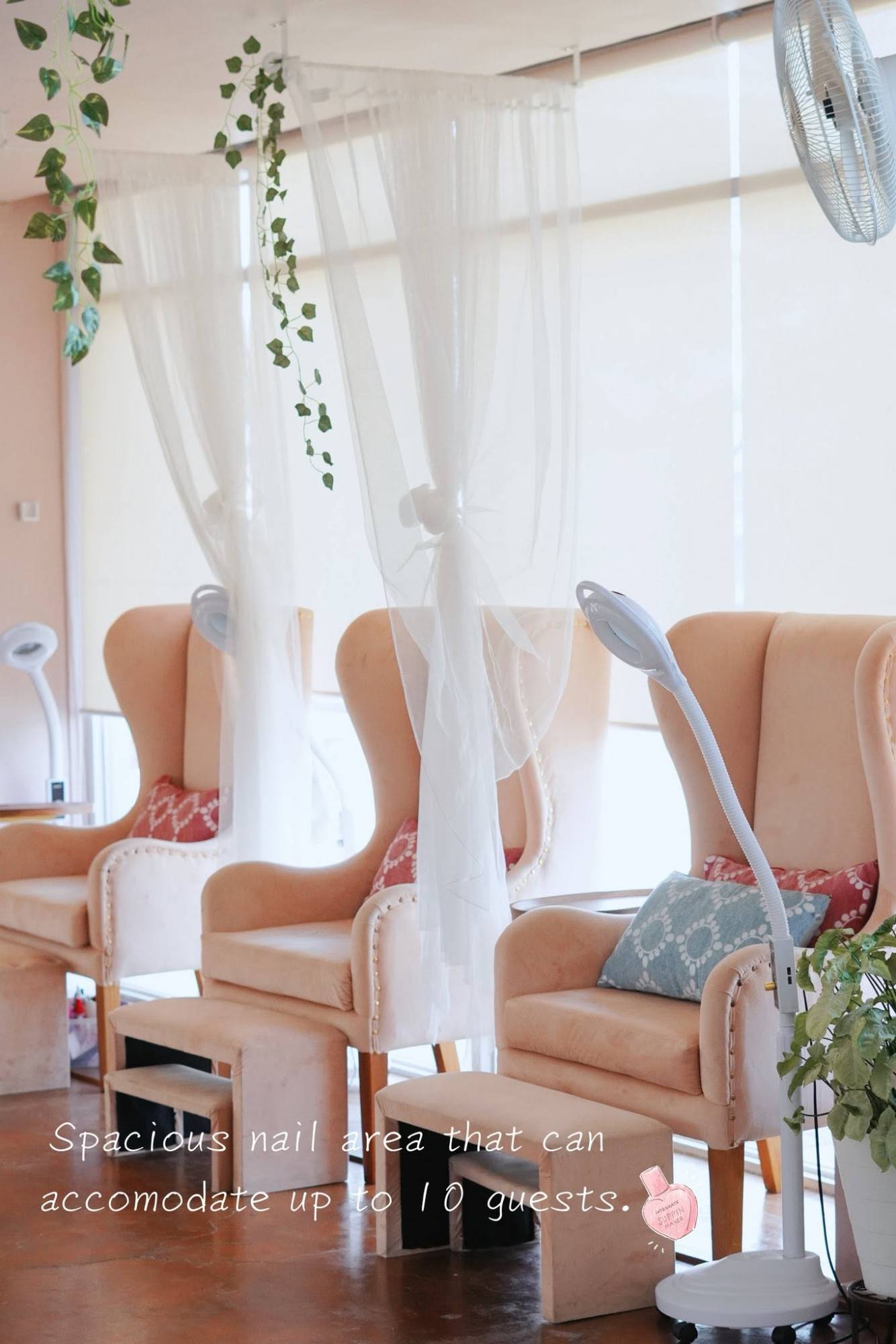 Nail area with a row of blush velvet chairs and foot rests
